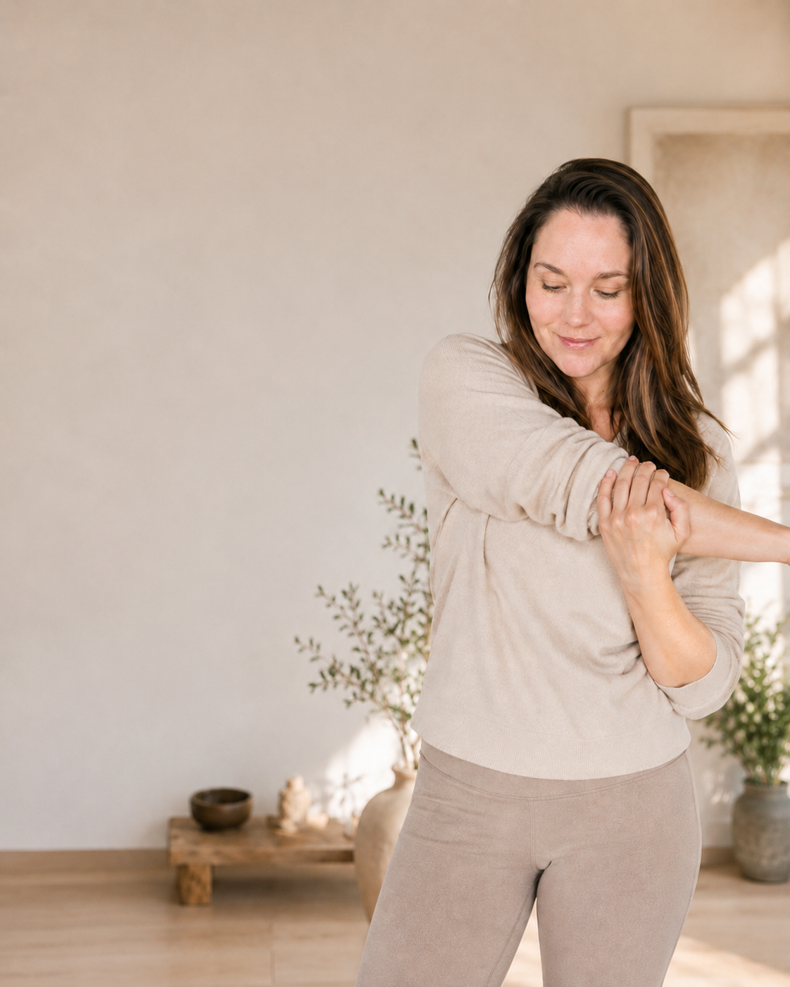 Jade Asher gently stretching in a calm, light-filled studio space